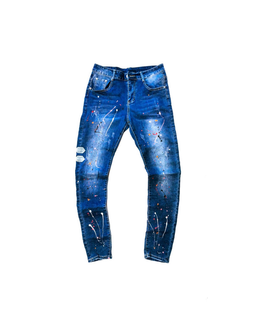 Blue distressed skinny jeans with paint splatter accents on white background